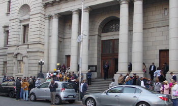 A group of local folk on the steps outside Cape Town High Court holding placards demonstrating against building on theit sacred lands