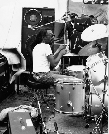 black and white photo of Byron Lye-Fook playing drums playing live on stage