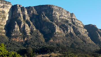 colour photo showing the east side (Fernwood) of Table Mountain featuring the African 'dawn' shadow face showing on the face of the Fernwood buttress.