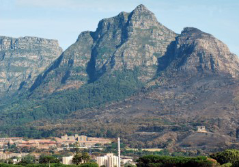 monstrous looking mountain looms on the horizon facing up in defiance of the clear blue sky overhead