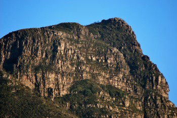 a closer view of the sandstone layers on Devil's Peak lit by a yellow orange light from early morning sunlight.