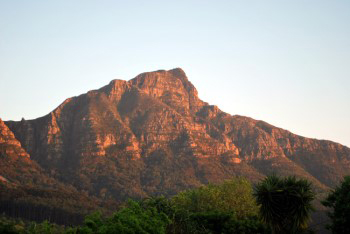 Devil's Peak like a burning coal under warm orange red sunrise light.