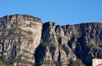 Clear light view of Fernwood and Protea buttresses on clear sunny day with dark shadows and craggy sandstone layers clearly defined showing undulations in the formation of the layers.