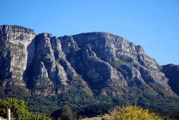 Sunlit view of the five buttresses with craggy outcrops throwing deep shadows out of one of which the shadow face is gradually forming.