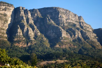 Panoramic view of buttresses in hazy warm sunshine with the shadow face fully formed resembling the features of a face in profile.