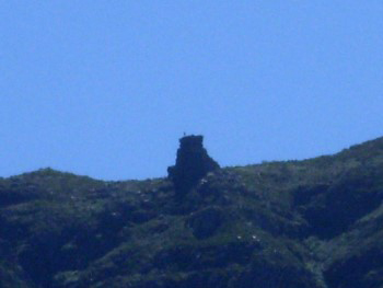 Hazy blue green view with tiny figure of a person on top of The Pulpit waving and shows just how huge is The Pulpit